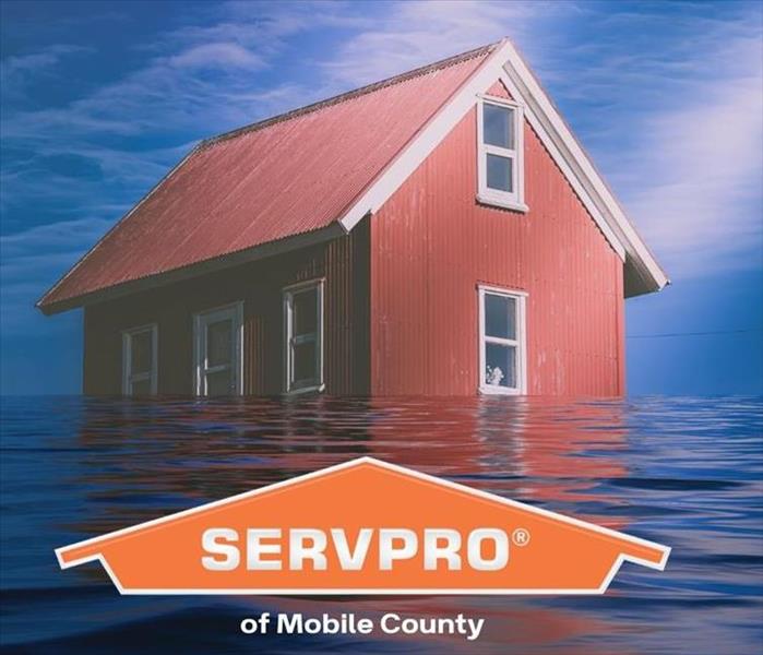 red house with water surrounding it and orange SERVPRO logo