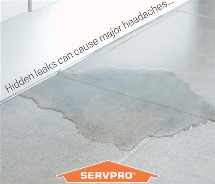 white baseboard on grey tile floor with water seeping out
